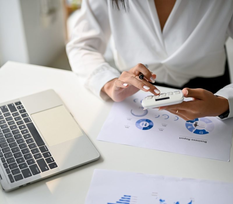 cropped-image-businesswoman-using-calculator-calculate-sales-working-her-desk